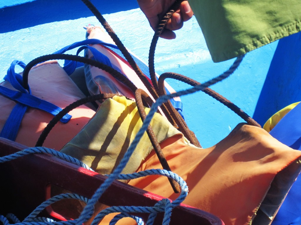 Komposition mit Schwimmweste, Anker, Fischershand und Badehose